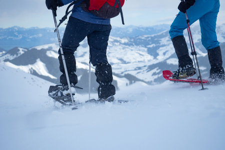 Two snow shoe hikers walking down from Kronberg, a mountain in Switzerlandの写真素材