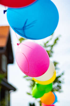 Birthday decoration: Balloons tied outside on a stringの写真素材