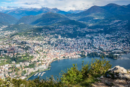 Lugano, Switzerland - October 6th 2021: View from Monte San Salvatore towards the city surrounded by mountainsの写真素材