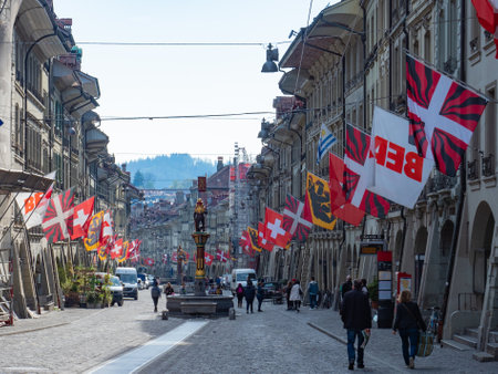 Berne, Switzerland - April 16th 2023: View along the main street decorated with flags in the...
