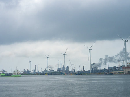 Rotterdam, Netherlands - August 4th 2024: Industrial landscape with wind generators at Europoort international harbour.のeditorial素材