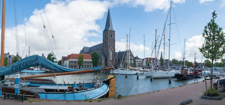 Harlingen, Netherlands - August 7th 2023: Marina with sailboats in front of the city churchのeditorial素材