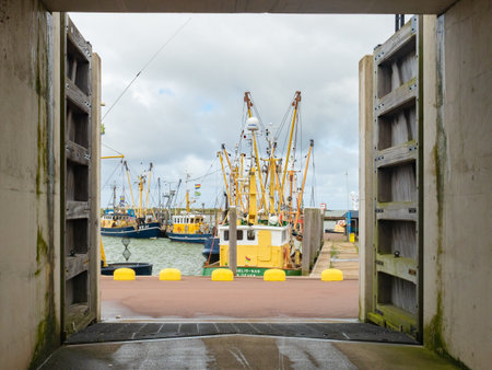Den Oever, Netherlands - August 6th 2023: Flood barrage in front of the fishing harbour with boatsのeditorial素材
