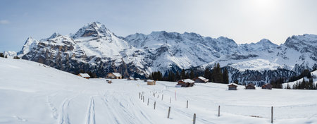 Muerren, Switzerland - February 21st 2024: Beautiful huts in the skiing resort in front of Jungfrau peakの写真素材