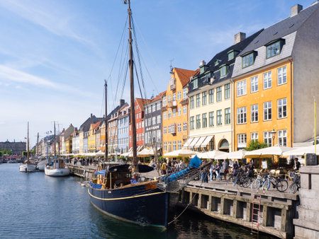 Copenhagen, Denmark - June 3rd 2025: Colourful houses and famous promenade along the historic quai...