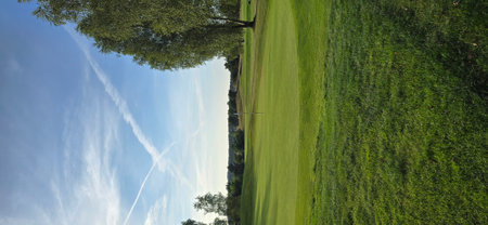 Aerial view of a golf course with green grass and blue sky