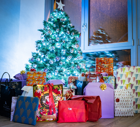Christmas tree full of presents and presents during Christmas nightの写真素材
