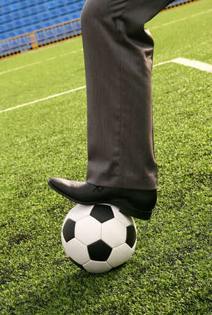 Businessman with soccer ball in stadiumの写真素材