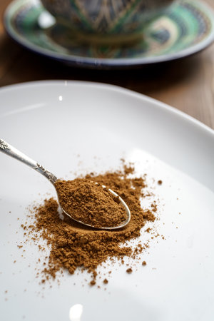Ground cumin seeds in a spoon on a white plateの写真素材