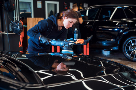 Female Technician Polishing Car with Bufferの写真素材