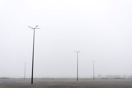 Street lights on a deserted parking lot in fog