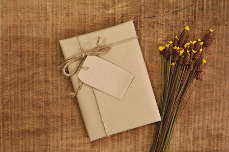 Gifts made from recycled brown paper and grass flower on a wooden texture to someone special.の写真素材