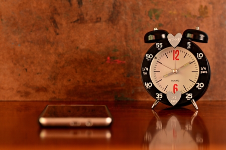 The clock on the desk empty but still have the watch and smart phones focus on the clock.