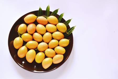 Marian plum on the plate and on a white background
