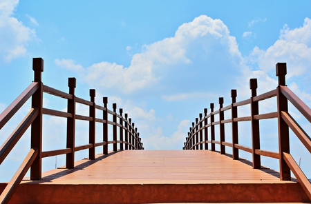 The bridge across the Canal to the Brown backdrop of the sky and clouds of white./ Bridge over the brown canal Blue sky background and white cloudsの写真素材
