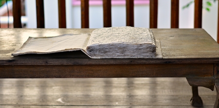 An old photo album on a vintage wooden desk.の写真素材