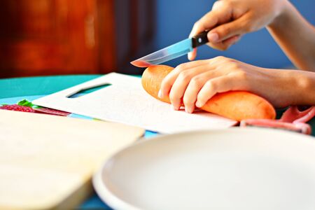 Cooks are preparing carrots. To cook Focus on the knife and carrot head, the background blurred.の写真素材