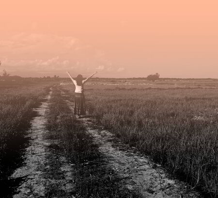 Young woman standing in the middle of the field, ozone arm freshly refreshing vintage style.の写真素材