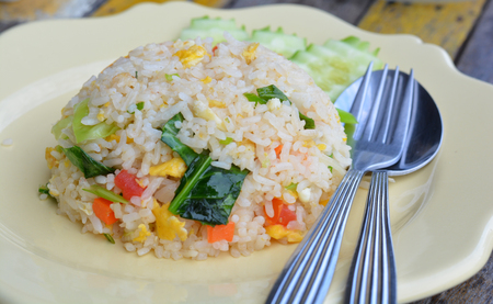 American Fried Rice in a Yellow Dish Put on Old Wooden Floor with Scenes Focus only on the rice dish.の写真素材