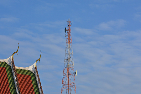 Phone Antenna And the church in Buddhism. Blue sky and fluffy white clouds are in the background.の写真素材