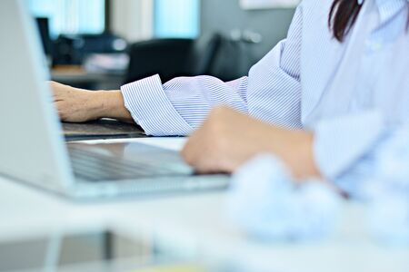Office workers are working online. / Focus on the right hand and armの写真素材