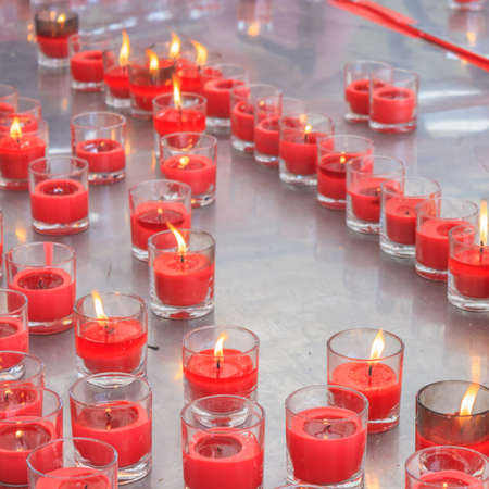 Candle in glass on aluminium table in temple の写真素材