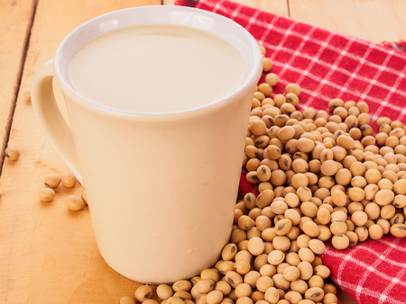 cup of soy-milk and soybeans on wood backgroundの写真素材