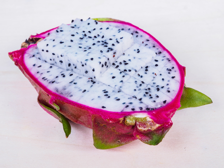 half of sliced dragon fruit on wood backgroundの写真素材