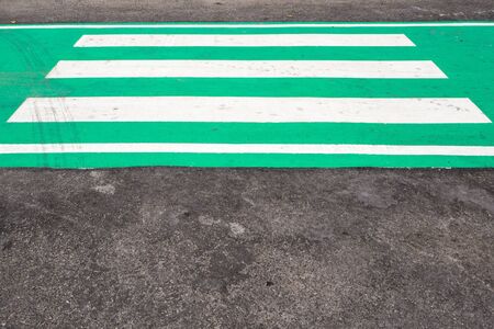 crosswalk on green asphaltの写真素材