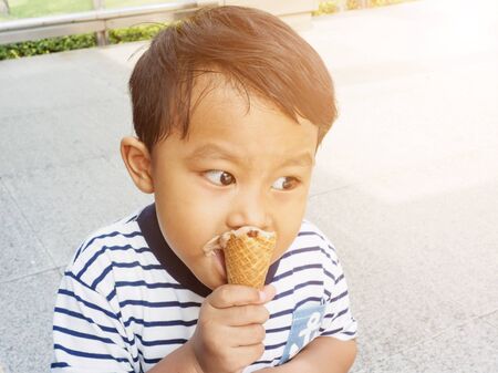 asian cute boy enjoy eating chocolate ice cream.