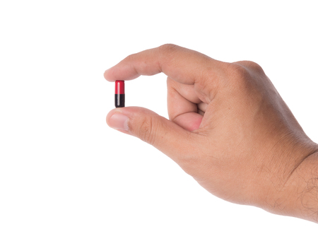 Hand holding a capsule or pill isolated on white with clipping path.の写真素材