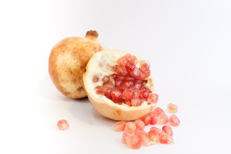 Ripe pomegranate fruit with half isolated on white backgroundの写真素材