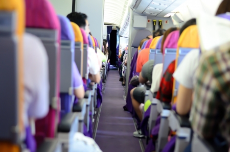 Interior of airplane with passengers on seatsの写真素材