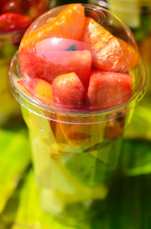 Fruit Salad arranged in plastic cups on a marketの写真素材