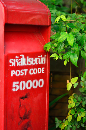 red post box set against nature background at Chiang mai Thailandの写真素材