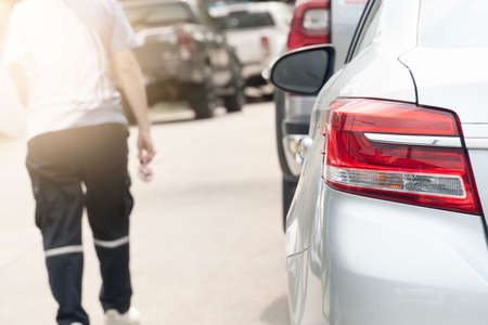 Rear of the car or taillight of silver car parking beside the road. with blurred of people walk through the street.の写真素材