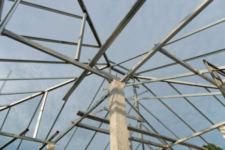 Steel roof structure connected to cement columns under the sky. Under the sky.