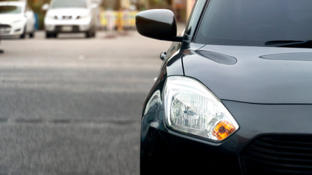 Front of black car on the road with blurred of other cars in the back