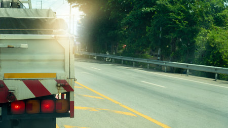 Brake light of truck car on the road. Green leave of tree beside of road. Empty road at days.の写真素材