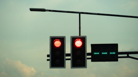 Red traffic lights with countdown numbers stroke for green light. Silhouette of traffic light on the...