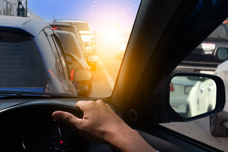 Hand of man driving car stop in traffic light, Single hand on steering wheel, Go to business trip or...