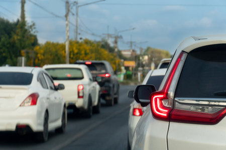 Cars on the road heading towards the goal of the trip. During the daytime traffic jam. Background...