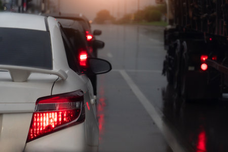 Rear side of white car with turn on brake light. on body with drop of water rain. and environment of...