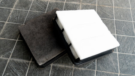 Old and new filters are stacked clearly on top of each other. Placed on a black tiled floor.の写真素材