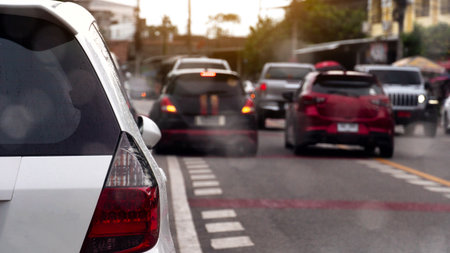 Rear side of white car stop beside road. WIth close popup of mirror wing. Many car driving on the...