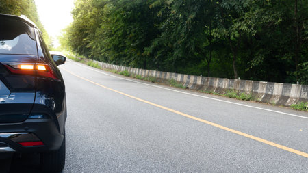 Rear side of dark blue car with turn light signal. Stop or travle to nature on asphalt road up to...