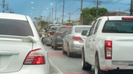 Cars are stuck in a traffic jam. Showing the back of the vehicles with a blurred background. Common...