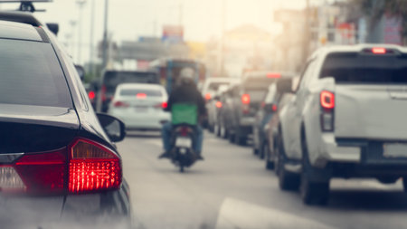 Rear side of grey car with trun on brake light. Traffic jam inthe city with many cars and motocycle. Atmosphere is like it is polluted with dust and smoke all around.の写真素材