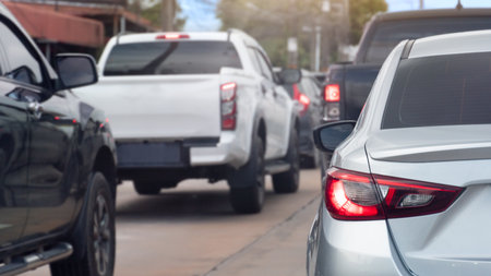 Rear side ov silver car with turn on brake light. Many car queue is full of traffic jams in the city.の写真素材