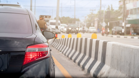 Rear side of black car with turn on brake light. Traffic condition on the road in the hot time of...